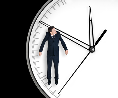 Businessman hangs on an arrow of clock