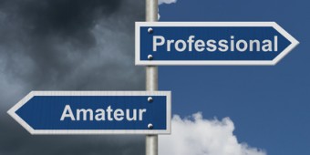 Difference between being a professional or an amateur , Two Blue Road Sign with text Professional and Amateur with bright and stormy sky background